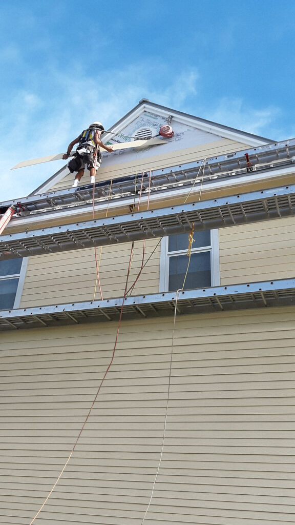 Man working on the wall outside of an attic