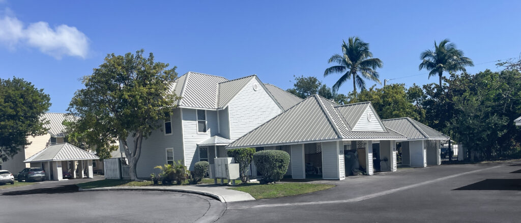 A distant picture of a house with light blue and gray roof