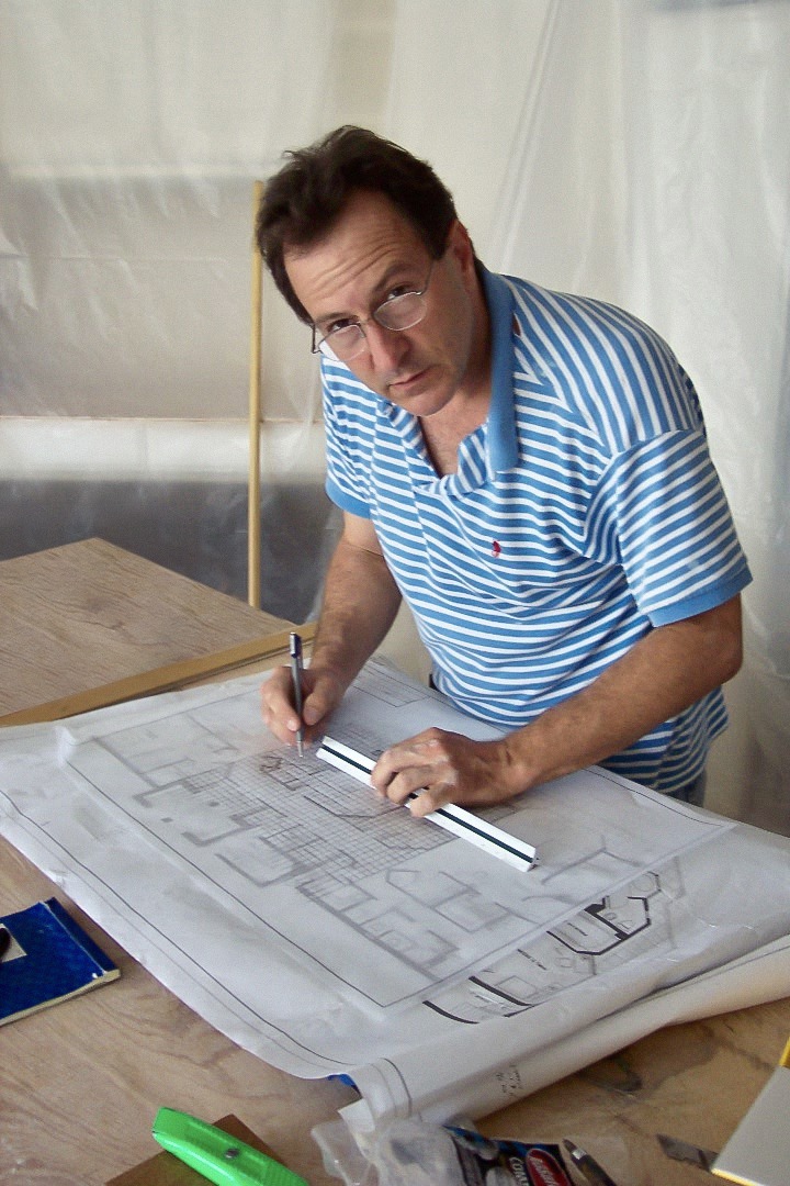 Man in blue drawing on a blueprint