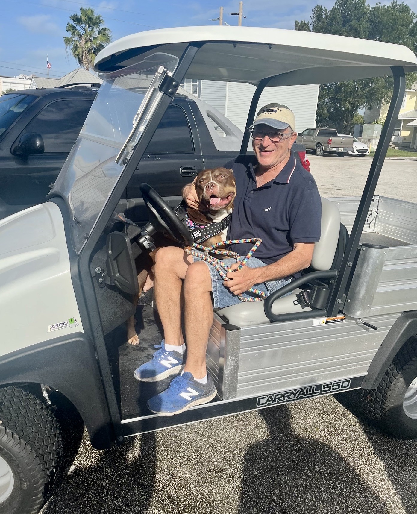 Man in a cap with his dog on a go cart